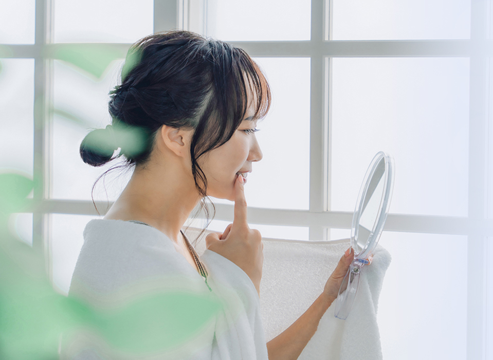 女性が歯を気にして鏡を見ている画像
